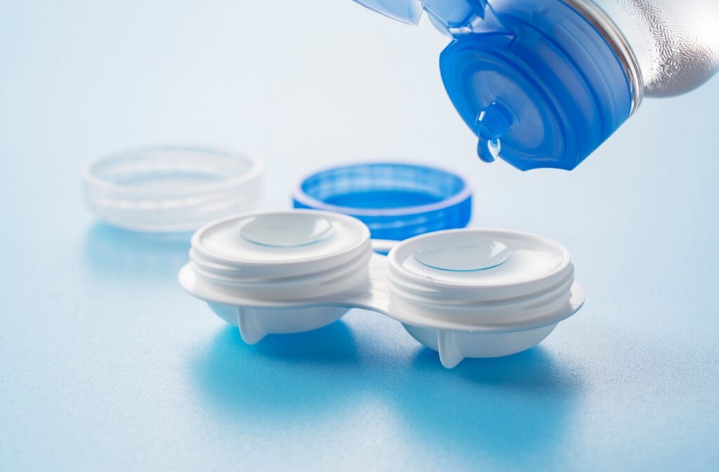 A new pair of contact lenses being cleaned in their containers with solution.