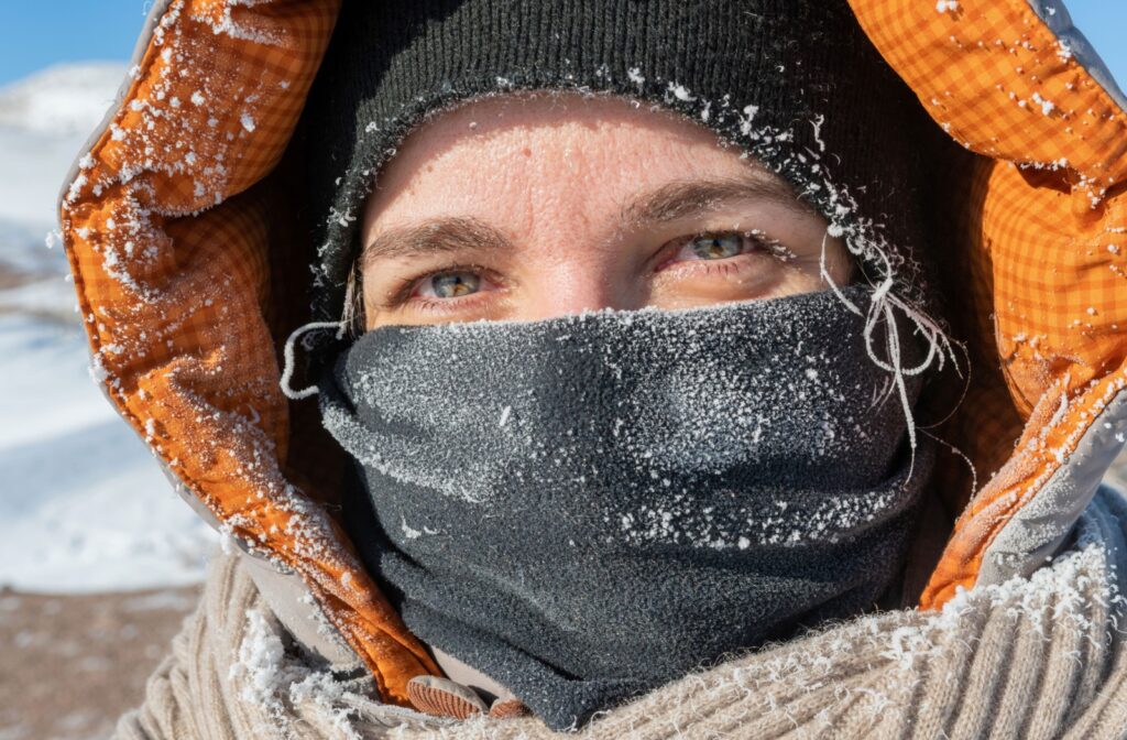 A person bundled up in warm winter clothing while standing outside in the snow