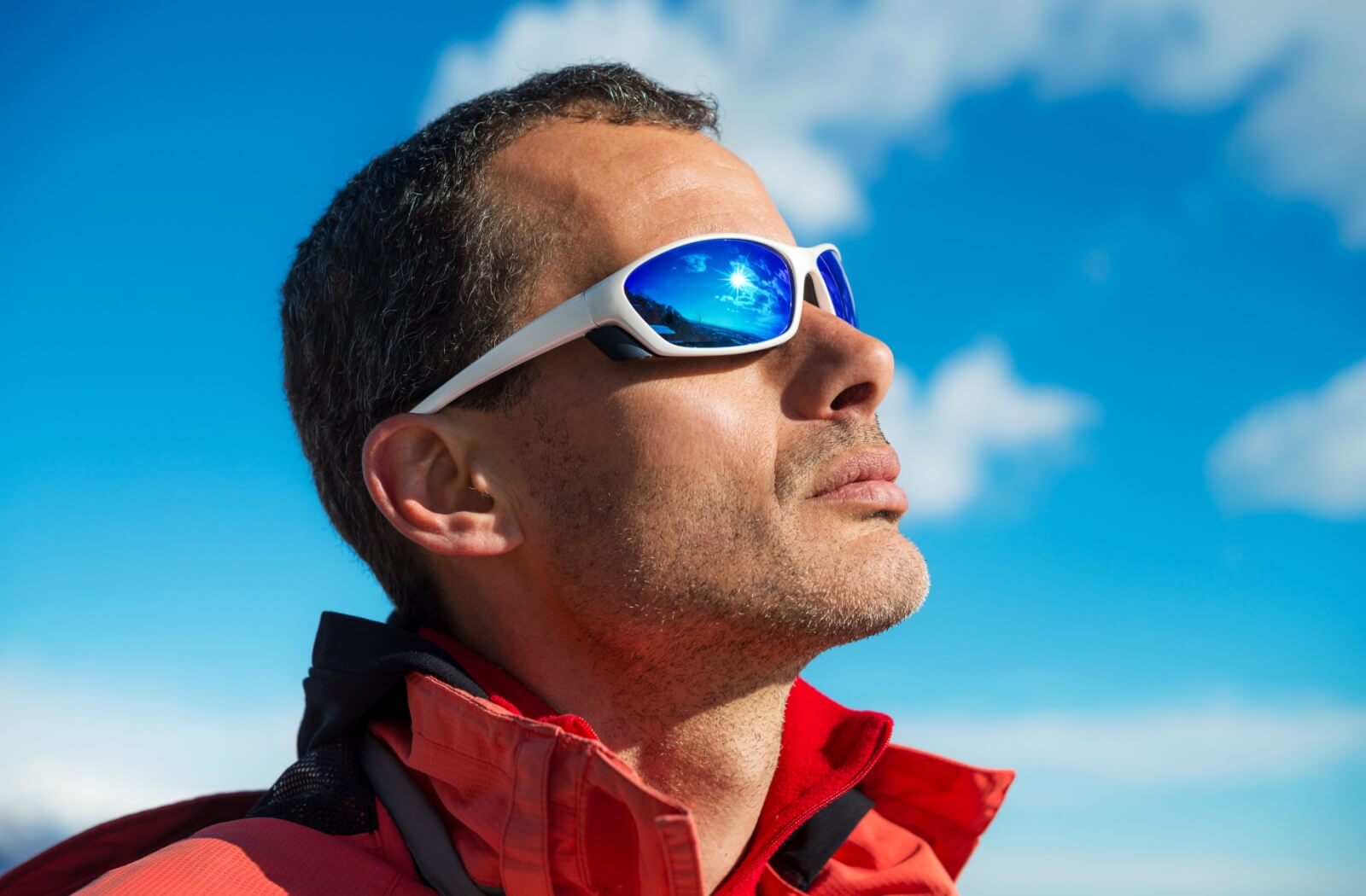 A person suffering from dry eyes wearing wraparound sunglasses while out in the cold to help protect their eyes from cold weather
