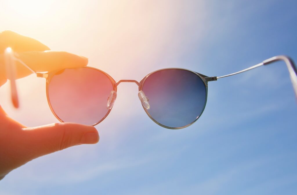 Polarized sunglasses held up to the sun to demonstrate glare reduction and lens clarity.