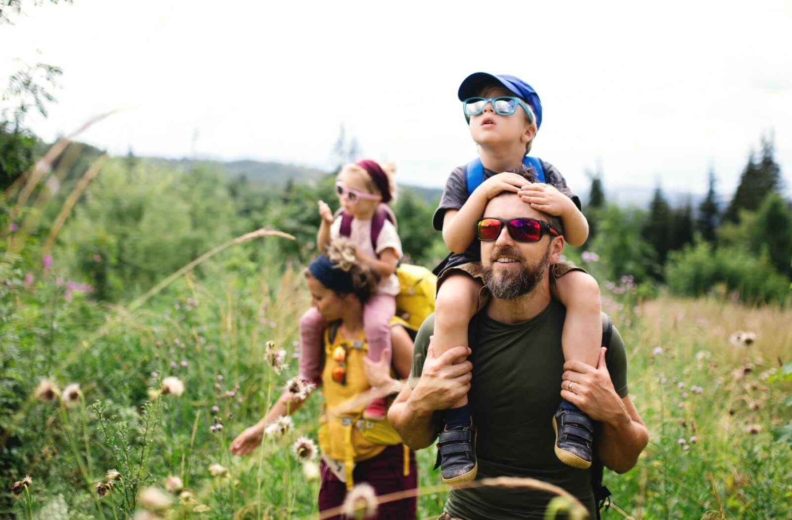 A family on a hike wears sunglasses to protect everyone's eyes.