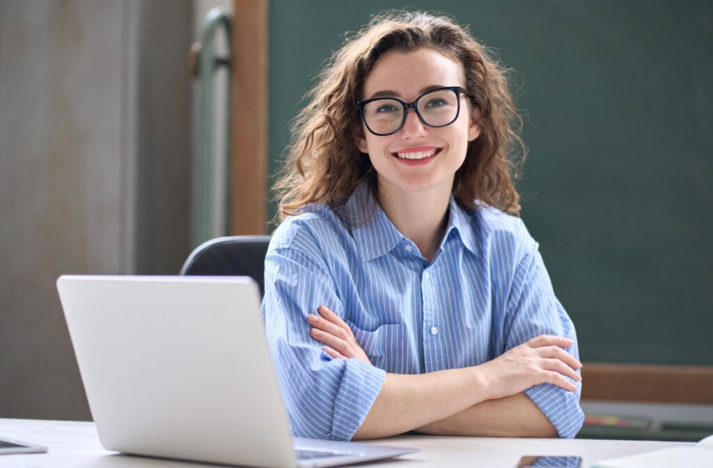 A person wearing glasses while sitting at their desk.
